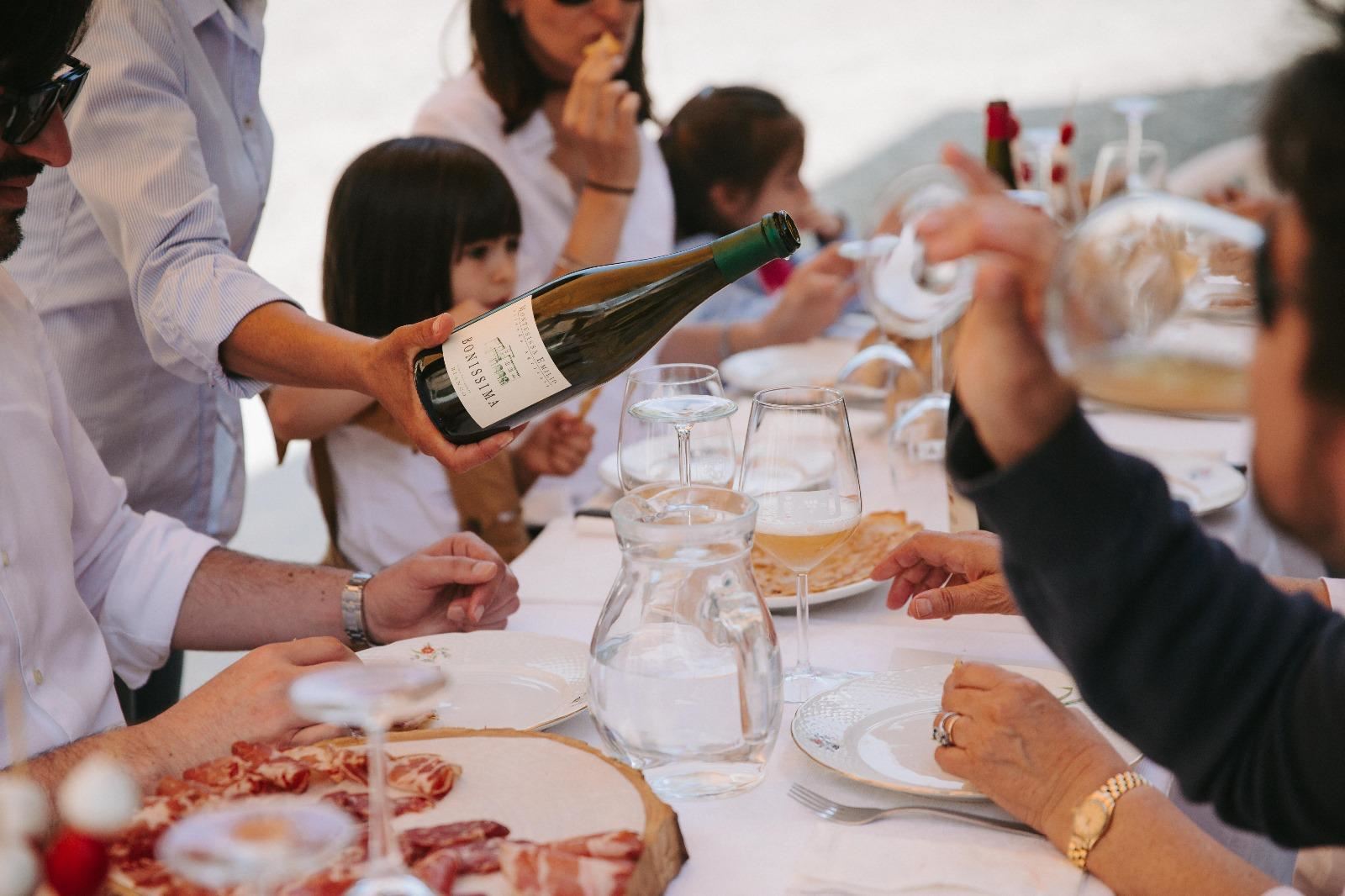 Un ospite versa il vino a tavola