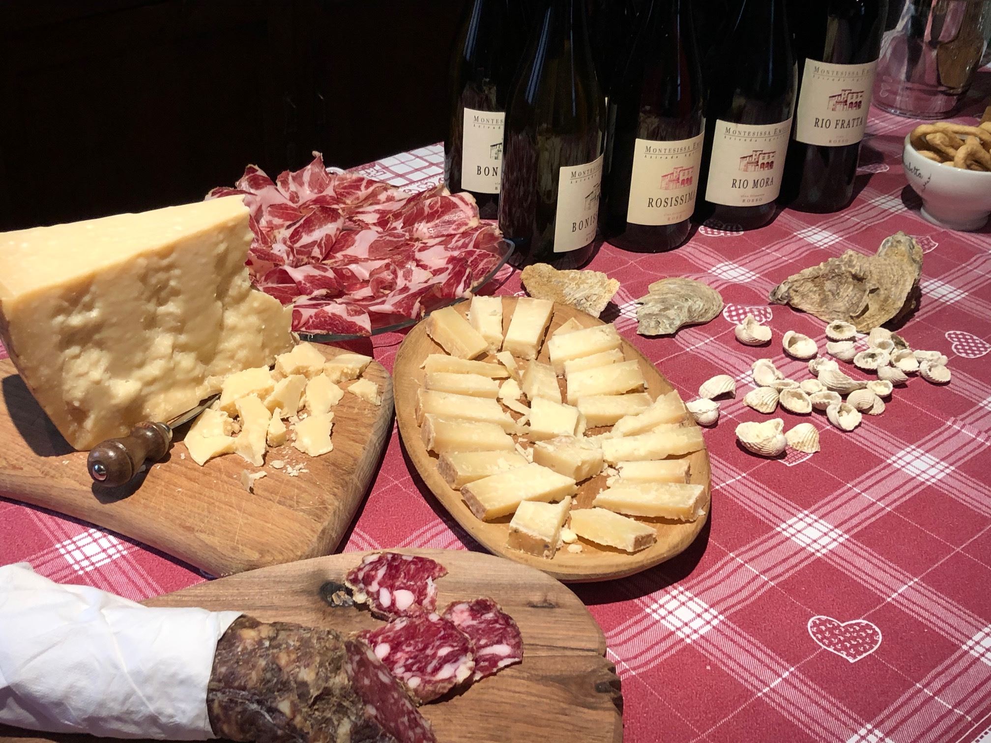 Tavola apparecchiata con formaggio, salumi piacentini e le bottiglie Montesissa