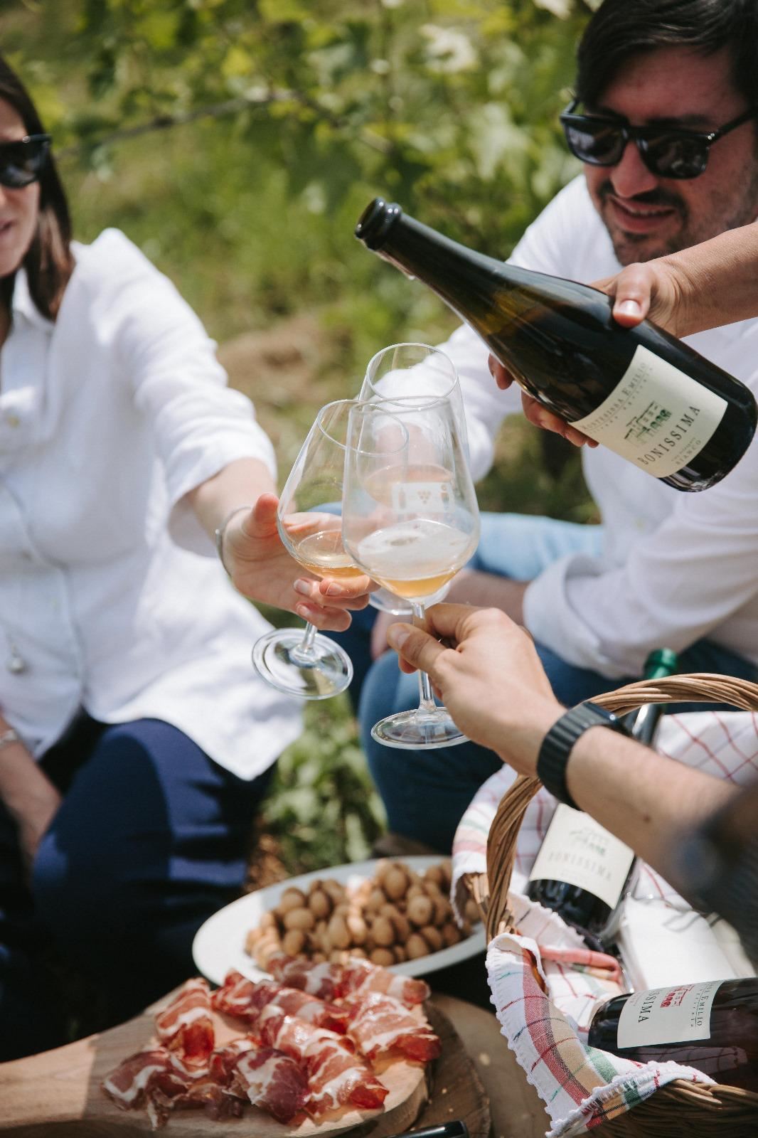 Un calice di vino bianco frizzante viene versato durante un picnic